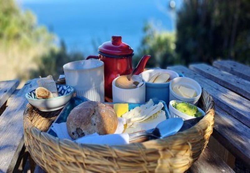 Cesta de desayuno con productos locales frente al mar en Ko Glamping.