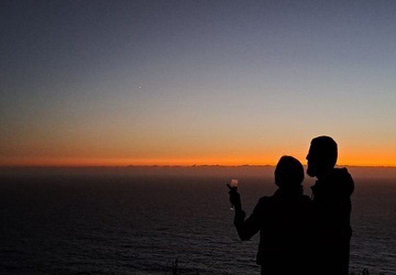 Silueta de pareja frente al mar de noche en Ko Glamping tras puesta de sol.