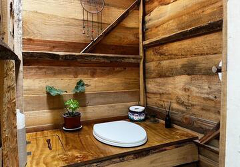 Interior de baño seco ecológico de Ko Glamping, mostrando construcción en madera.