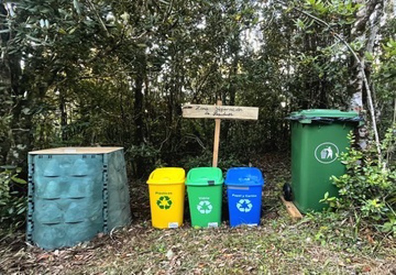 Punto de reciclaje en Ko Glamping con contenedores para residuos orgánicos, papel, vidrio y plástico.