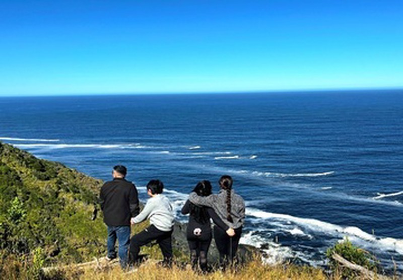 Grupo de espaldas contemplando el océano tras trekking guiado en Ko Glamping.